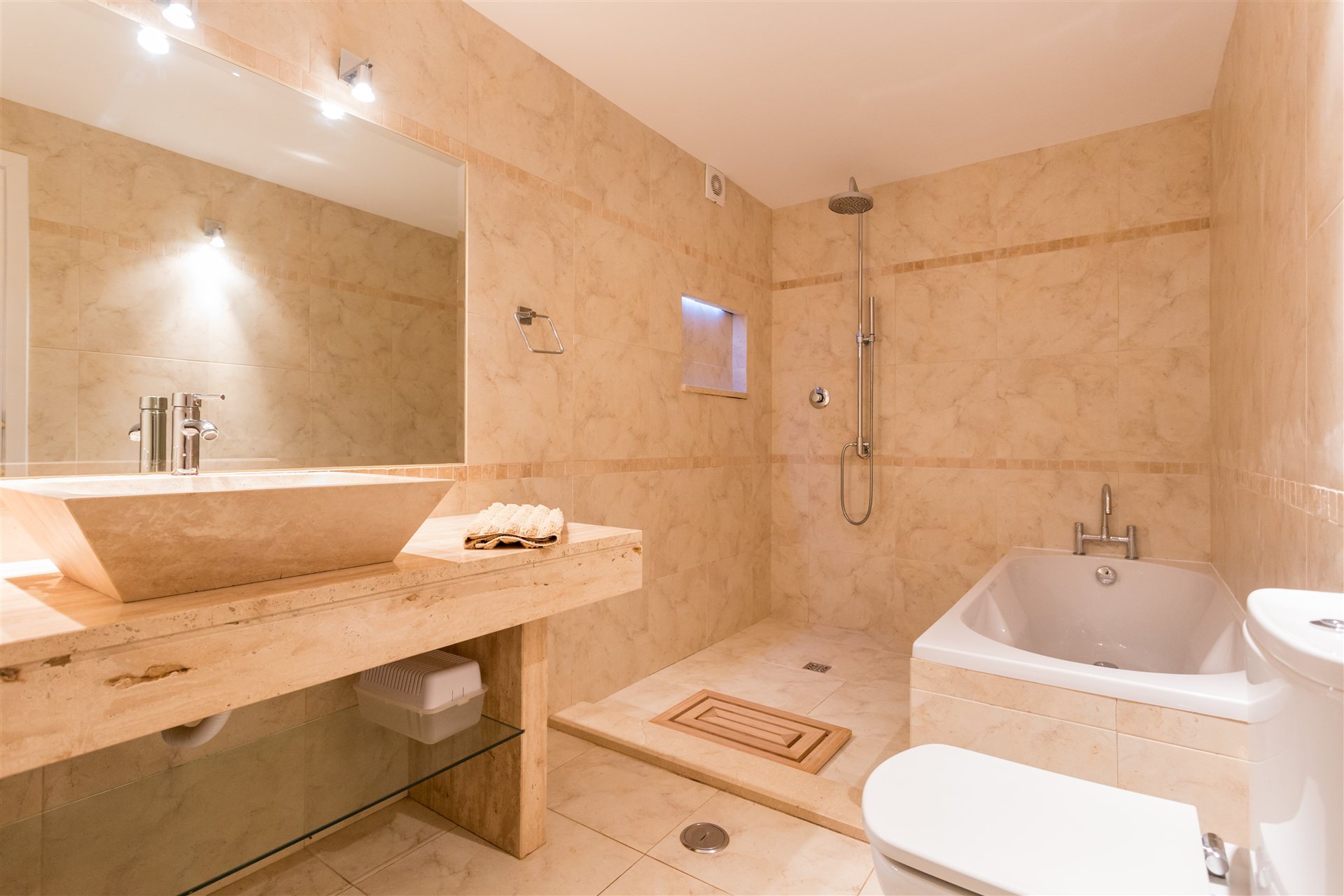 Stone en-suite bathroom with bath and shower